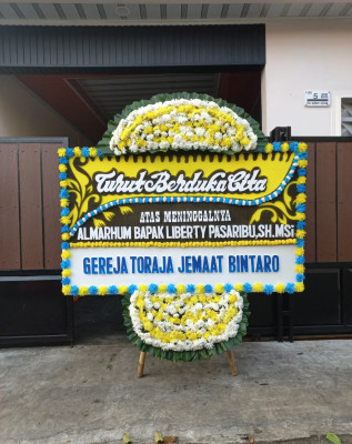 Papan Bunga Duka di Panggung Rawi